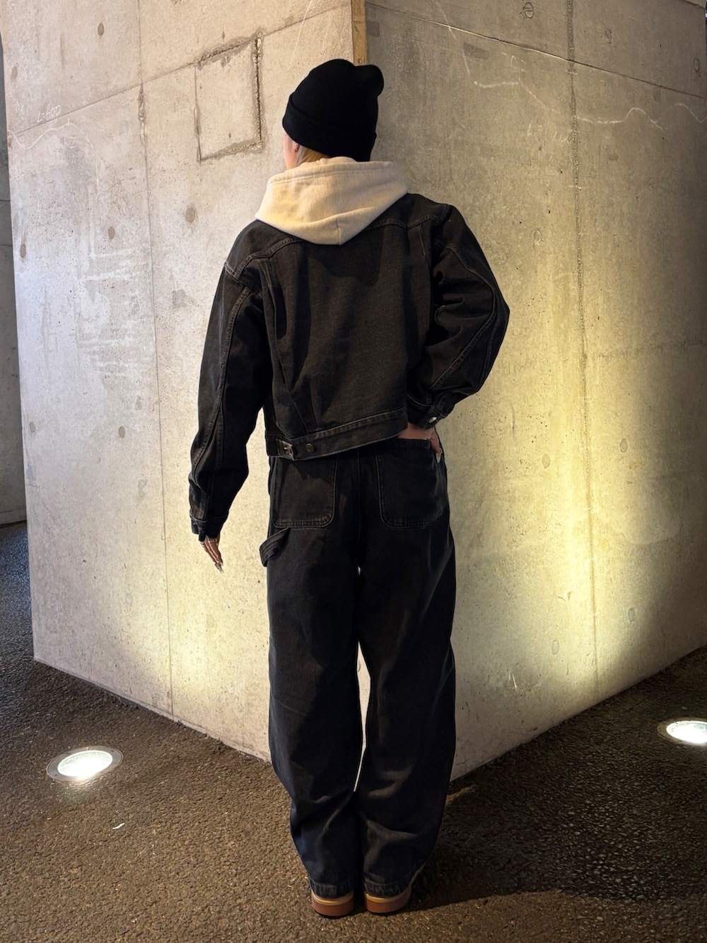 ベージュ系のパーカー、ブラック系のデニムパンツ、ブラック系のデニムジャケットを着用したレディースの春コーディネートの2枚目の写真