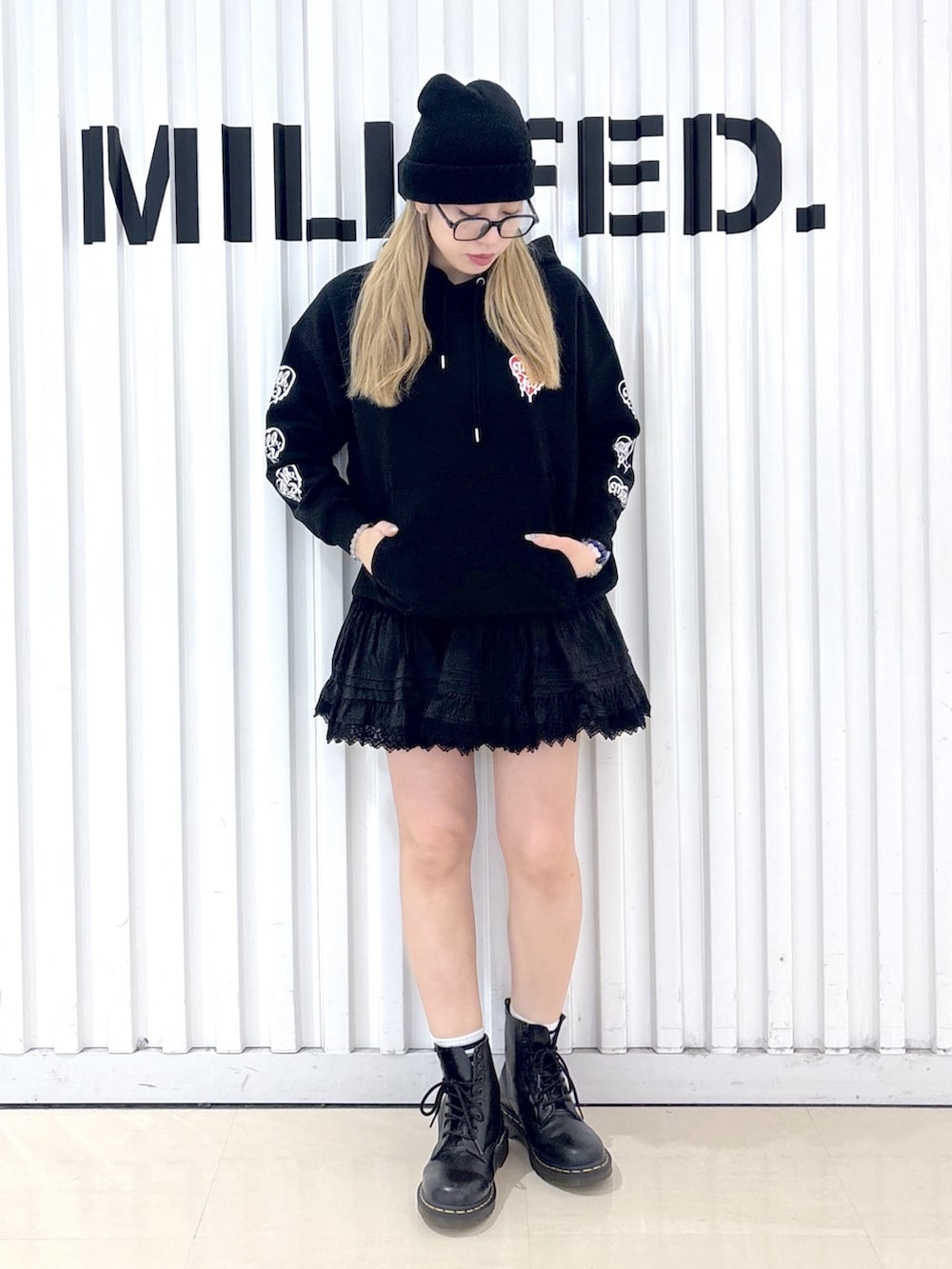 ブラック系のパーカー、ブラック系のスカート、ブラック系のボストンバッグを着用したレディースの春コーディネートの3枚目の写真