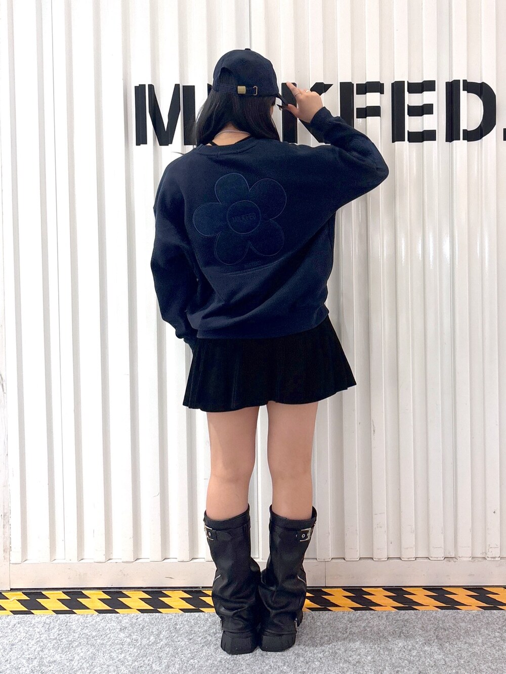 レッド系のスウェット、ホワイト系のベスト、ブラック系のその他パンツを着用したレディースの秋コーディネートの7枚目の写真