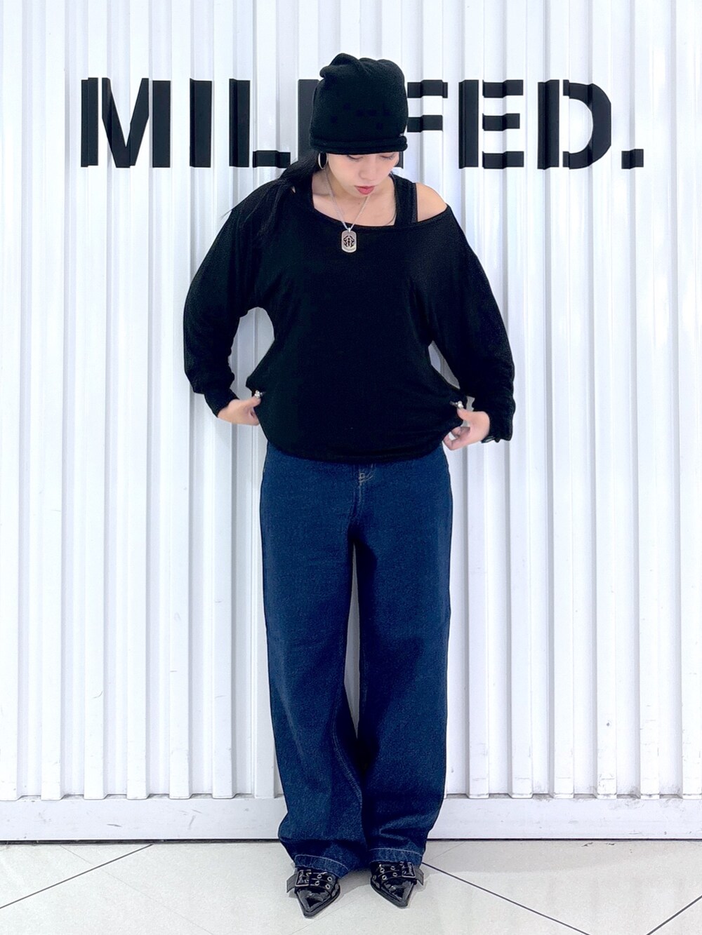 ブルー系のデニムパンツ、ブラック系のTシャツ/カットソー、ブラック系のニットキャップ/ビーニーを着用したレディースの秋コーディネートの5枚目の写真