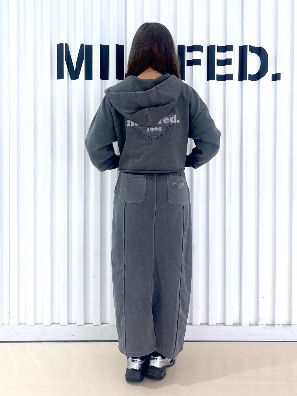 ブラック系のパーカー、ブラック系のスカートを着用したレディースの冬コーディネートの2枚目の写真