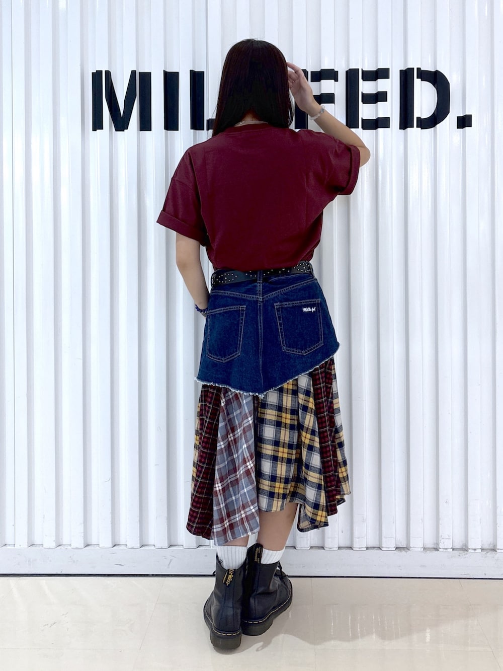 グレー系のショルダーバッグ、レッド系のTシャツ/カットソー、ブルー系のジャンパースカートを着用したレディースの秋コーディネートの4枚目の写真