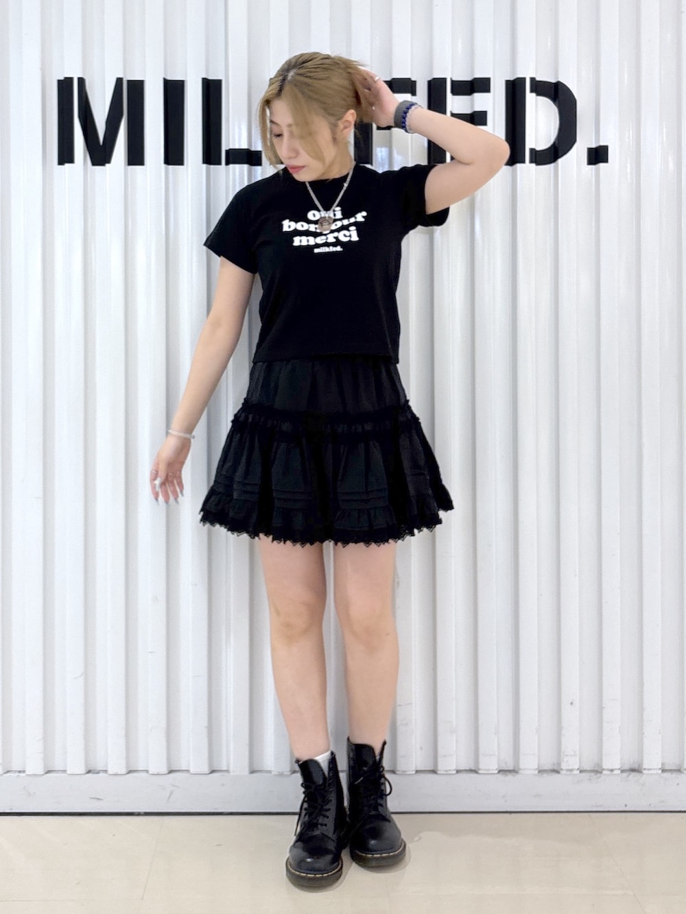 ホワイト系のショルダーバッグ、ブラック系のスカート、ブラック系のTシャツ/カットソーを着用したレディースの夏コーディネートの3枚目の写真