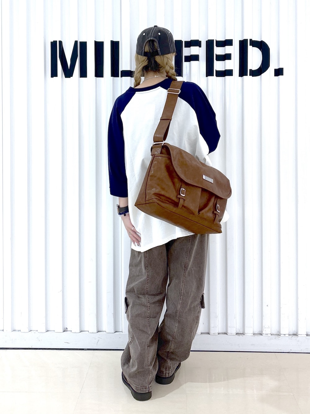 ブラウン系のショルダーバッグ、ブラウン系のその他パンツ、ホワイト系のTシャツ/カットソーを着用したレディースの春コーディネートの2枚目の写真