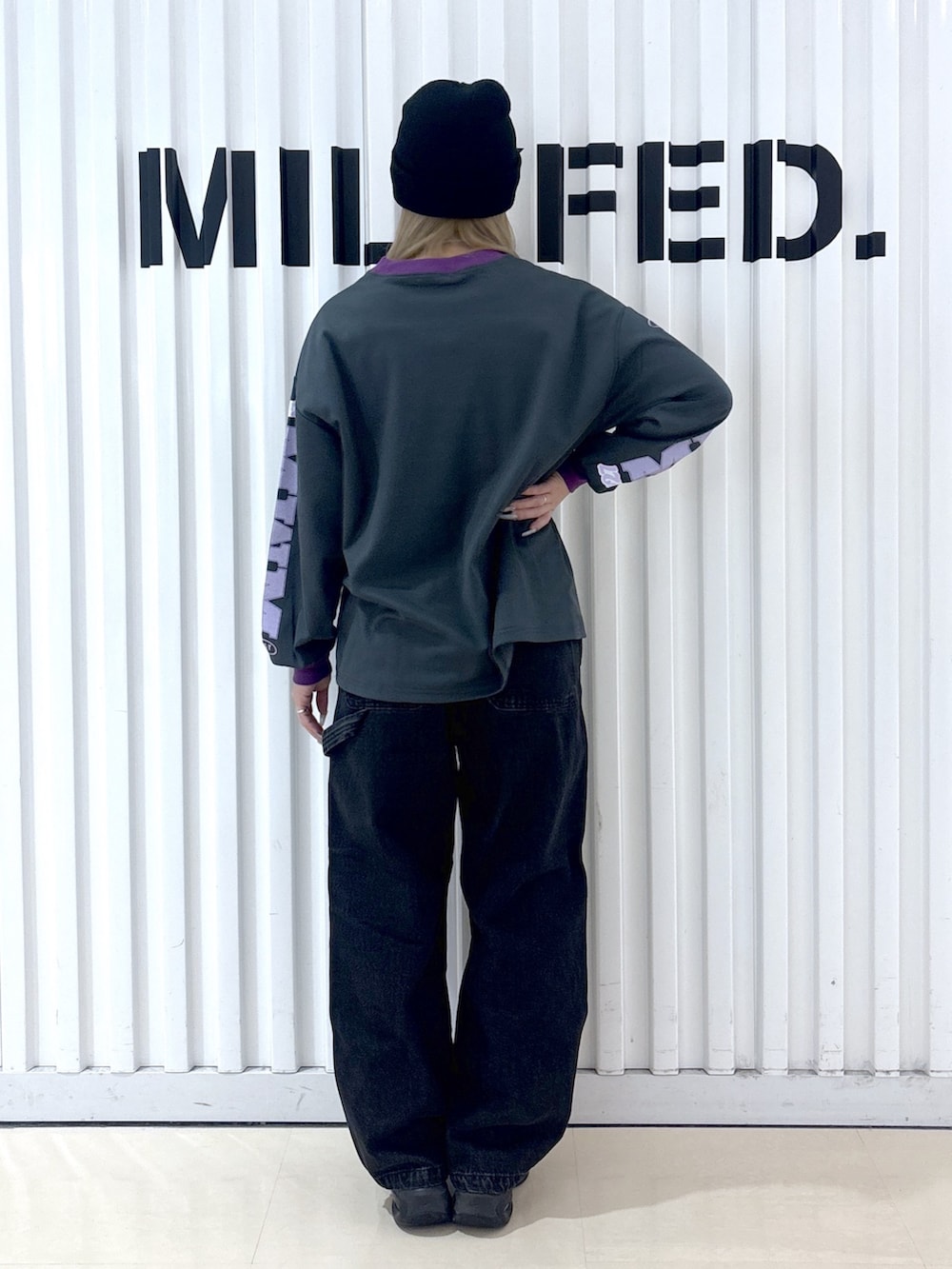 グレー系のTシャツ/カットソー、ブラック系のデニムパンツ、ブルー系のショルダーバッグを着用したレディースの冬コーディネートの4枚目の写真