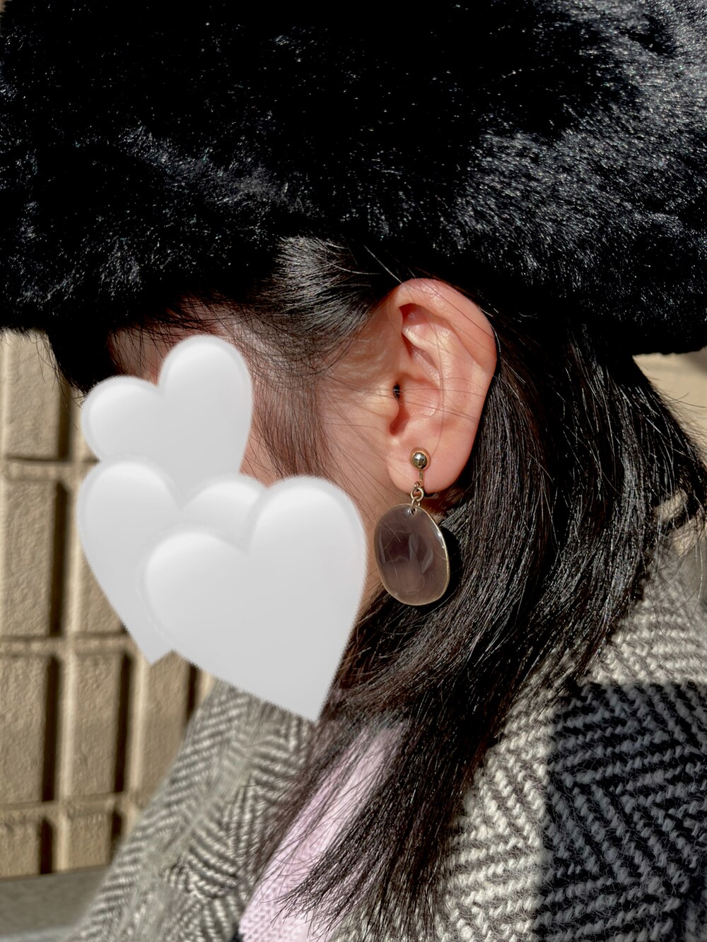 ホワイト系のクラッチバッグ、ブラック系のブーツを着用したレディースの冬コーディネートの2枚目の写真