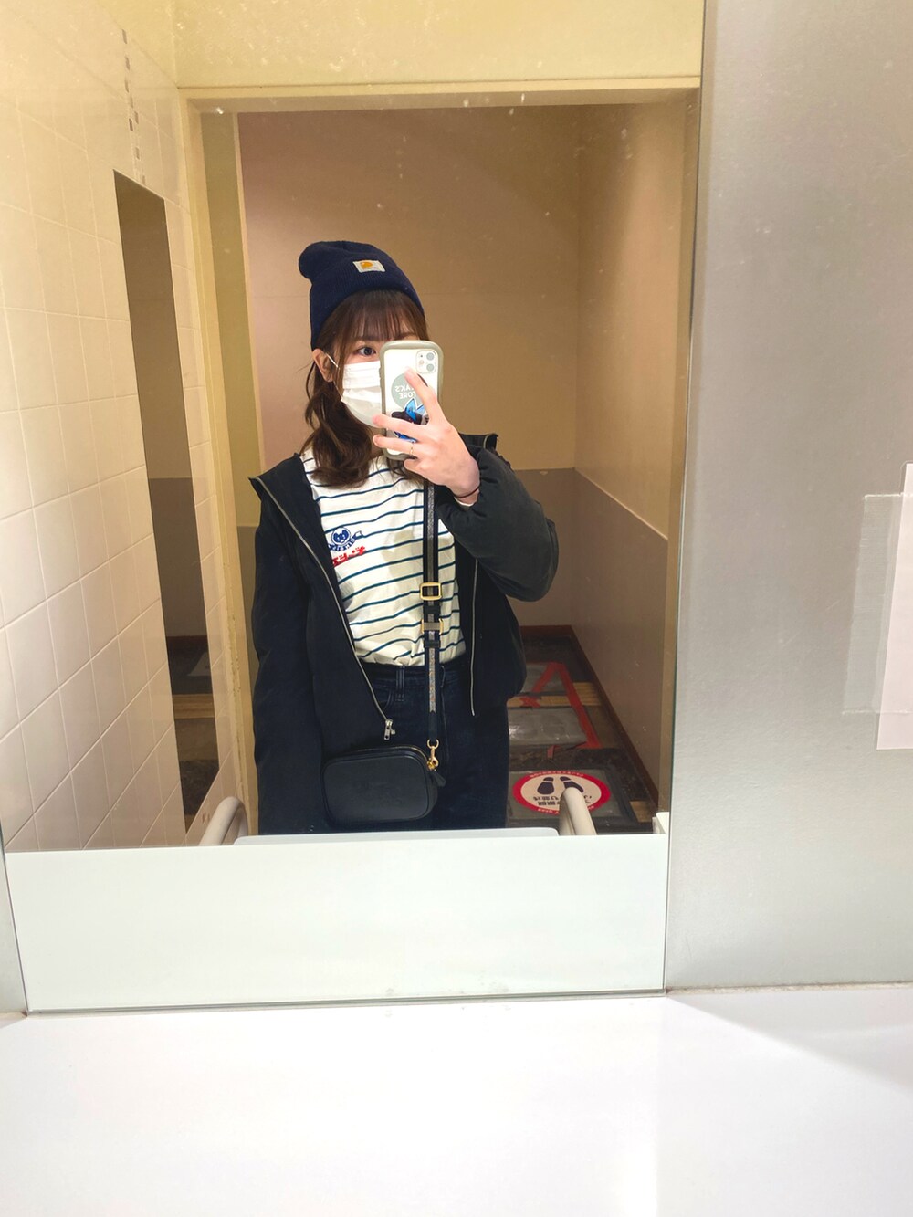 ホワイト系のTシャツ/カットソー、ブラック系のショルダーバッグ、ブラック系のデニムパンツを着用したレディースの冬コーディネートの2枚目の写真