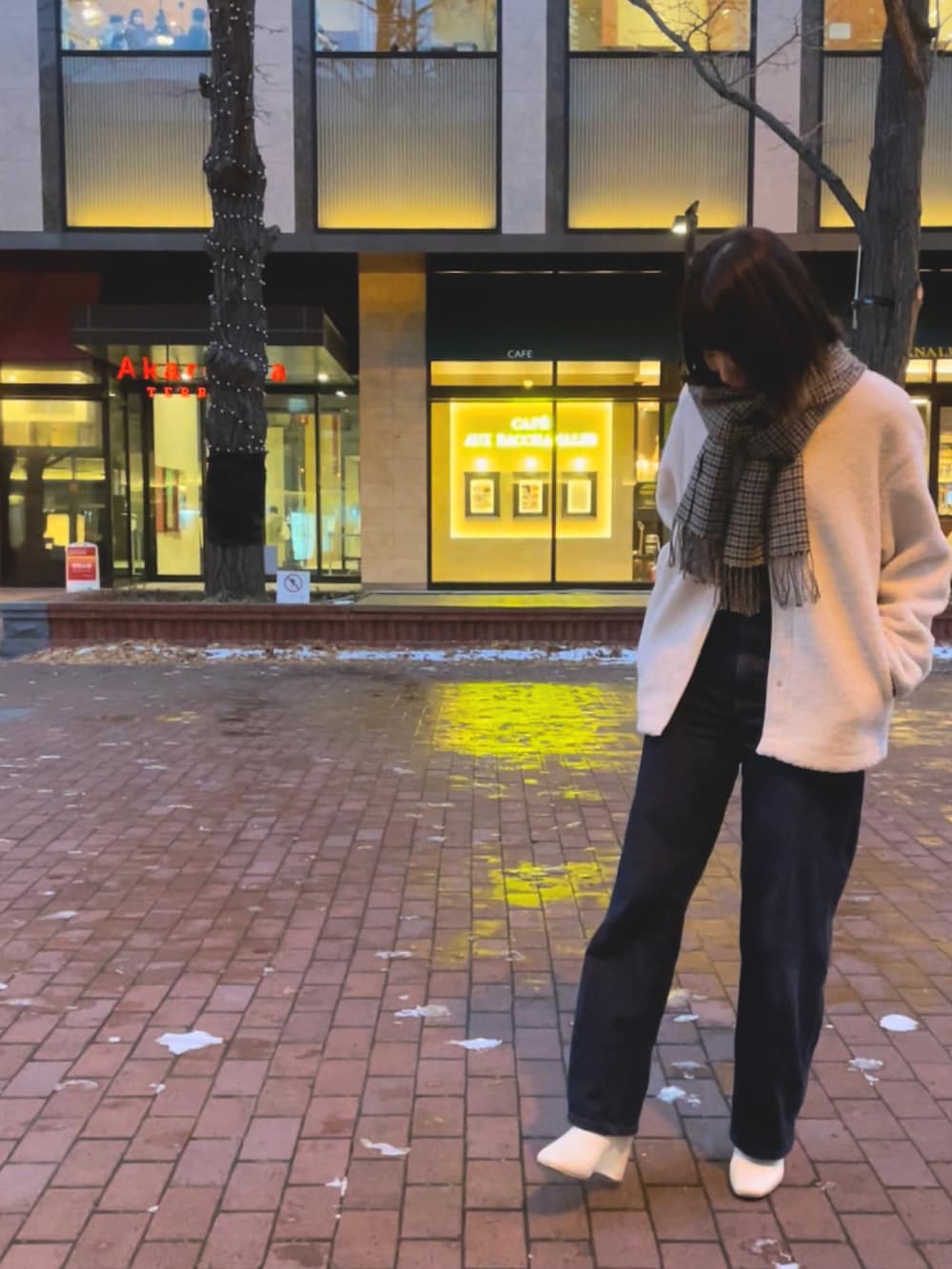 ブルー系のデニムパンツ、ベージュ系のジャケット/アウター、グリーン系のトップスを着用したレディースの冬コーディネートの2枚目の写真