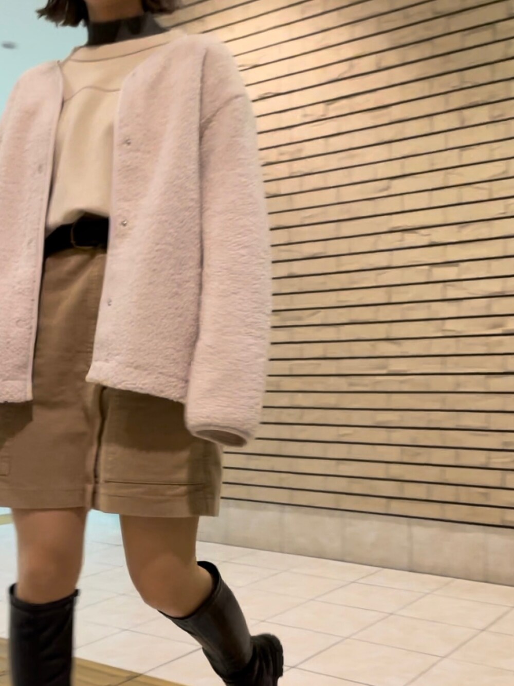 ブラック系のブーツ、ベージュ系のスカート、ベージュ系のジャケット/アウターを着用したレディースの冬コーディネートの2枚目の写真