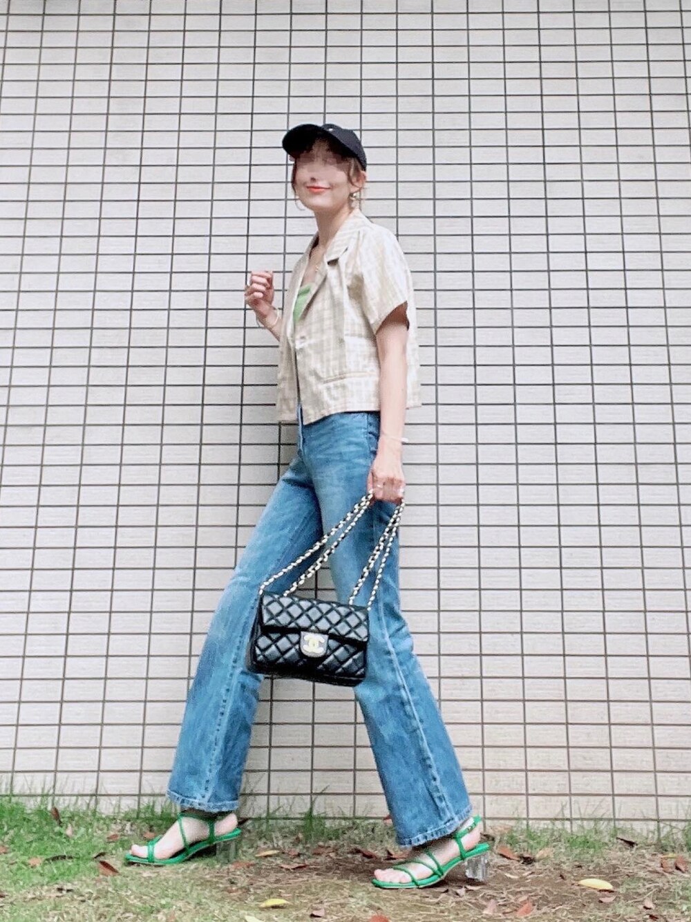ベージュ系のセットアップ、ブルー系のデニムパンツ、グリーン系のサンダルを着用したレディースの夏コーディネートの2枚目の写真