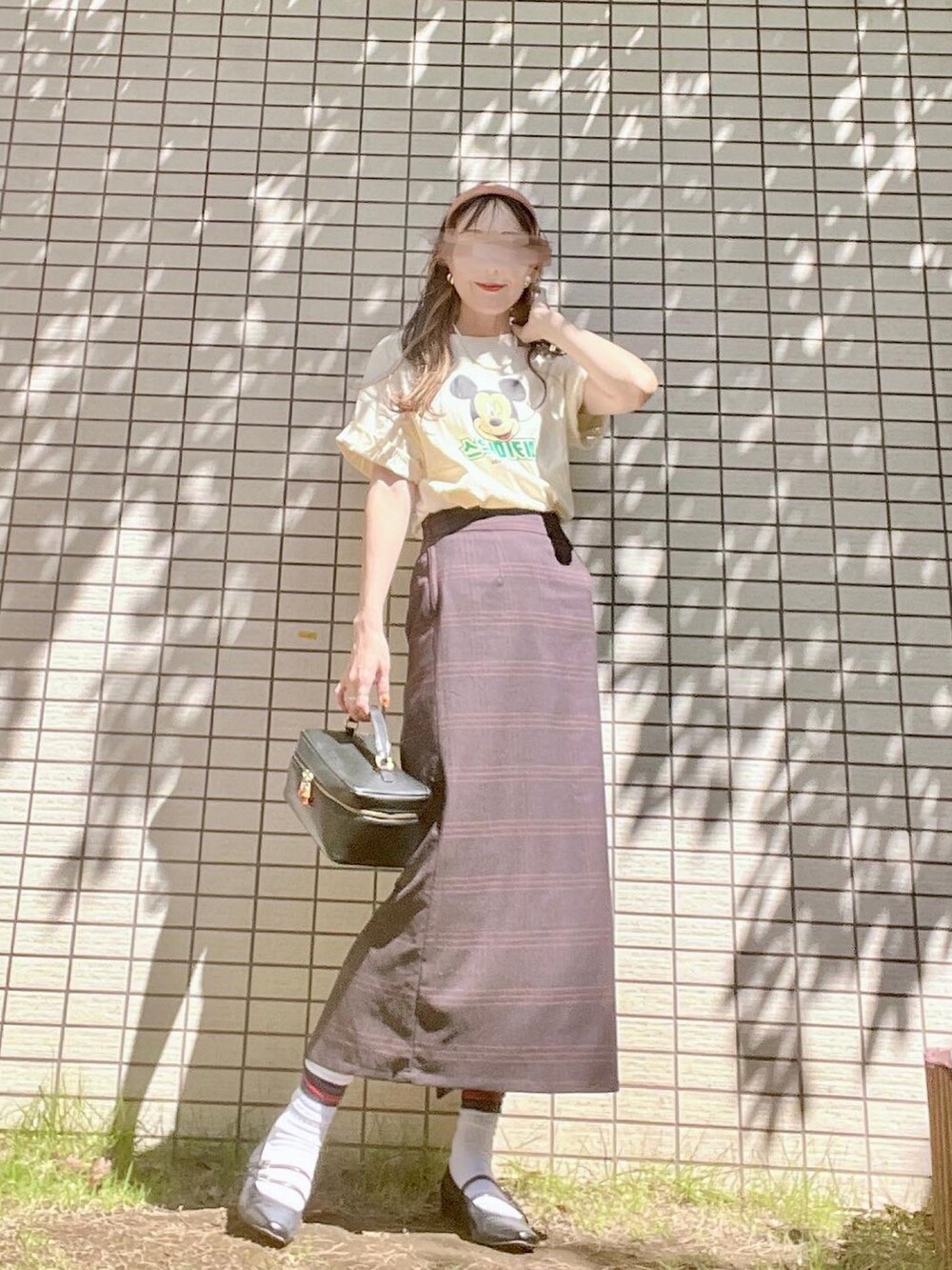 ホワイト系のTシャツ/カットソー、ブラウン系のスカート、ブラック系のバッグを着用したレディースの秋コーディネートの3枚目の写真