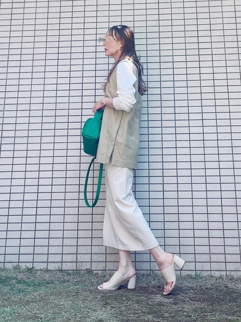 ベージュ系のベスト、ホワイト系のTシャツ/カットソー、ホワイト系のスカートを着用したレディースの春コーディネートの2枚目の写真