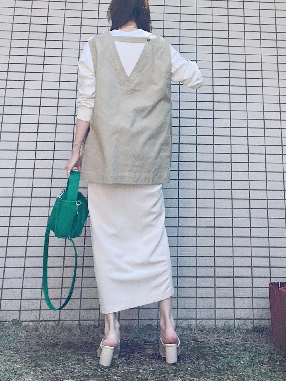 ベージュ系のベスト、ホワイト系のTシャツ/カットソー、ホワイト系のスカートを着用したレディースの春コーディネートの3枚目の写真