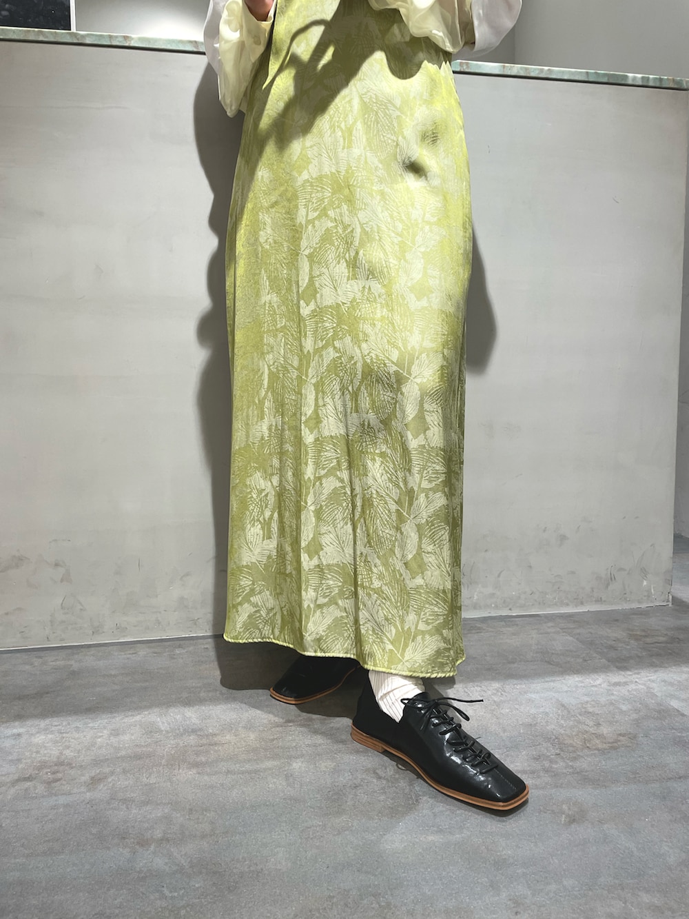 ホワイト系のTシャツ/カットソー、グリーン系のワンピース、ブラック系のドレスシューズを着用したレディースの春コーディネートの3枚目の写真