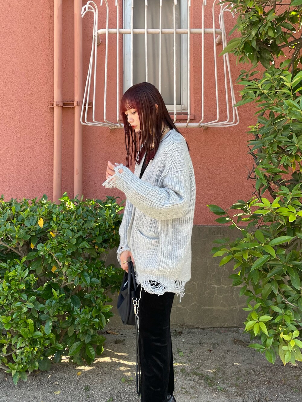 シルバー系のカーディガン/ボレロ、ブラック系のワンピース、ブラック系のショルダーバッグを着用したレディースの秋コーディネートの2枚目の写真