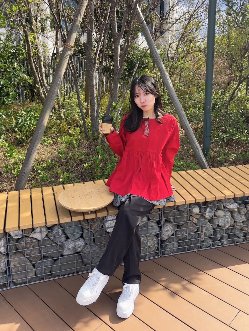 レッド系のトップス、ホワイト系のスニーカー、ブラック系のパンツを着用したレディースの春コーディネートの3枚目の写真