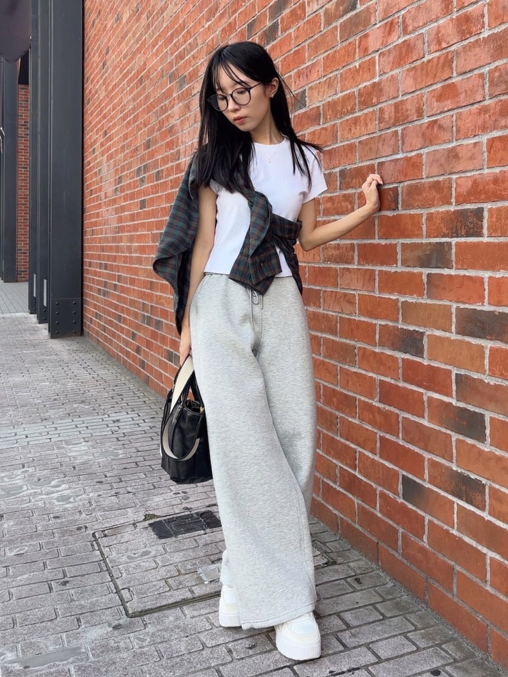 グリーン系のシャツ/ブラウス、ホワイト系のTシャツ/カットソー、グレー系のスウェットパンツを着用したレディースの秋コーディネートの2枚目の写真