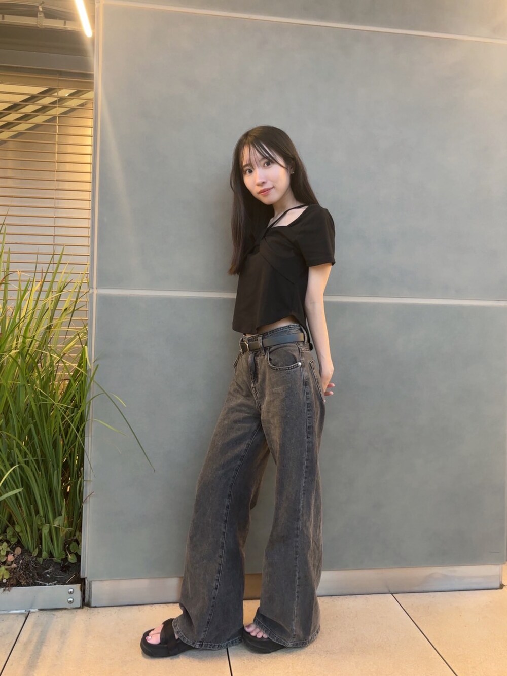 ブラック系のサンダル、ブラック系のTシャツ/カットソー、ブラック系のデニムパンツを着用したレディースの夏コーディネートの2枚目の写真
