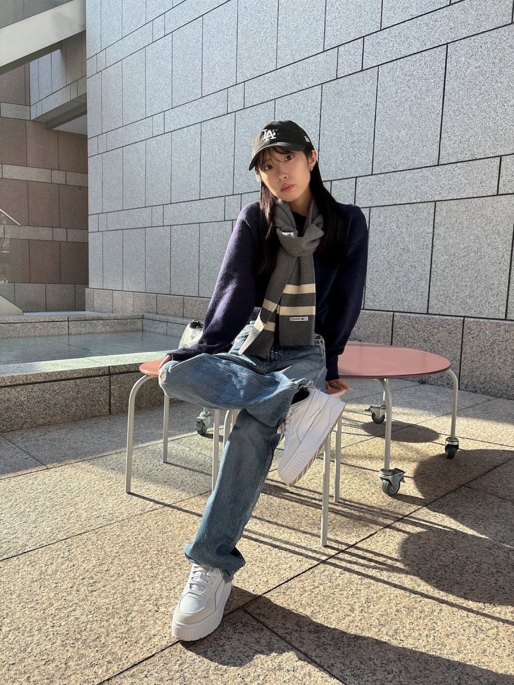 ブルー系のニット/セーター、ブルー系のデニムパンツ、ホワイト系のスニーカーを着用したレディースの冬コーディネートの2枚目の写真