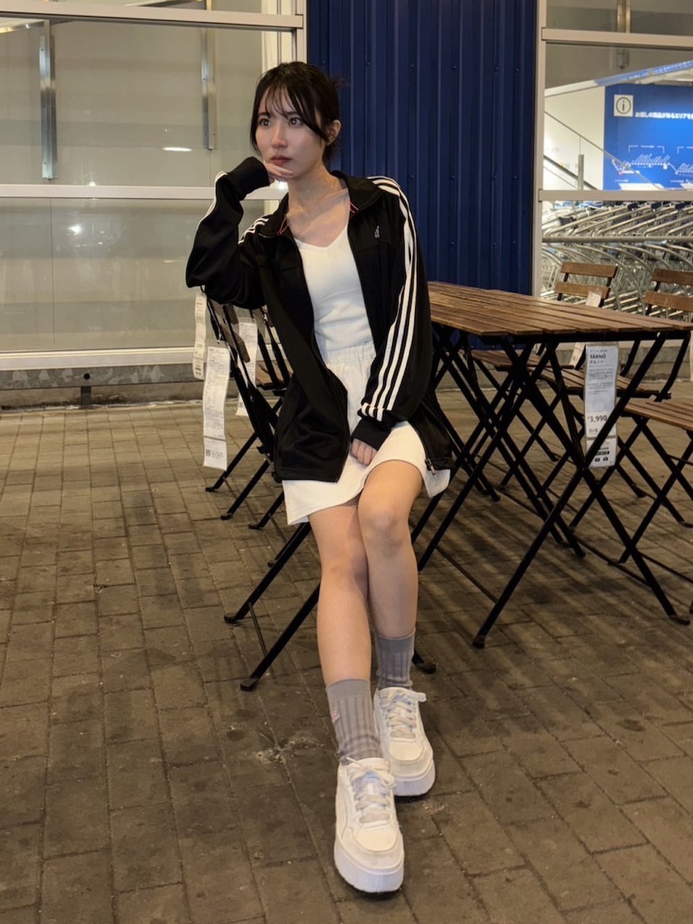 ホワイト系のスニーカー、ホワイト系のスカート、ブラック系のジャージを着用したレディースの春コーディネートの3枚目の写真