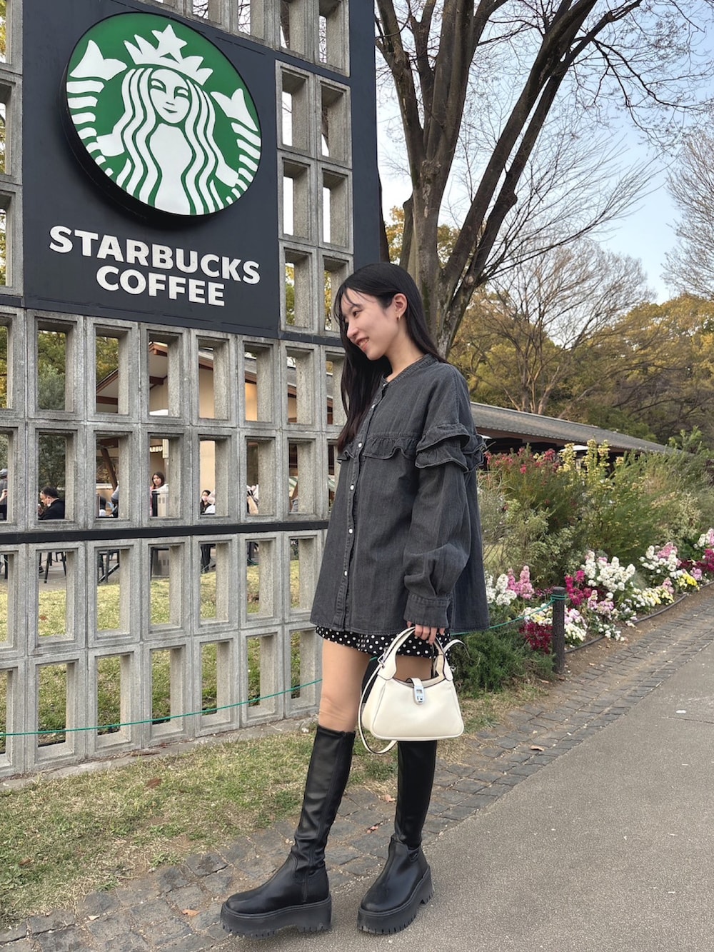 グレー系のシャツ/ブラウス、ブラック系のパンツ、ブラック系のブーツを着用したレディースの春コーディネートの2枚目の写真