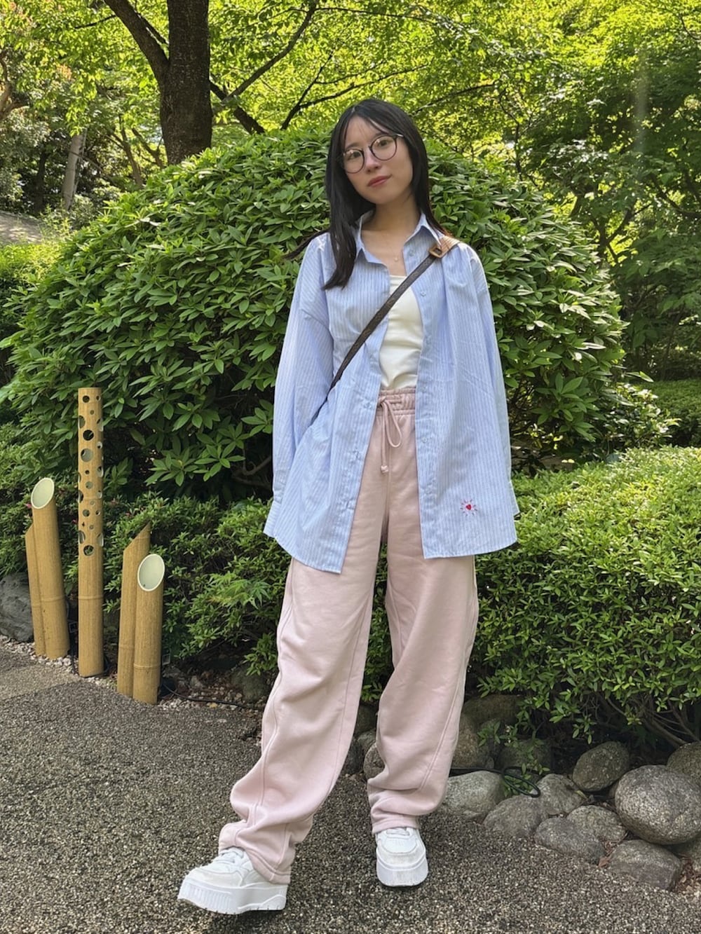 ブルー系のシャツ/ブラウス、ホワイト系のスニーカー、ホワイト系のキャミソールを着用したレディースの春コーディネートの2枚目の写真