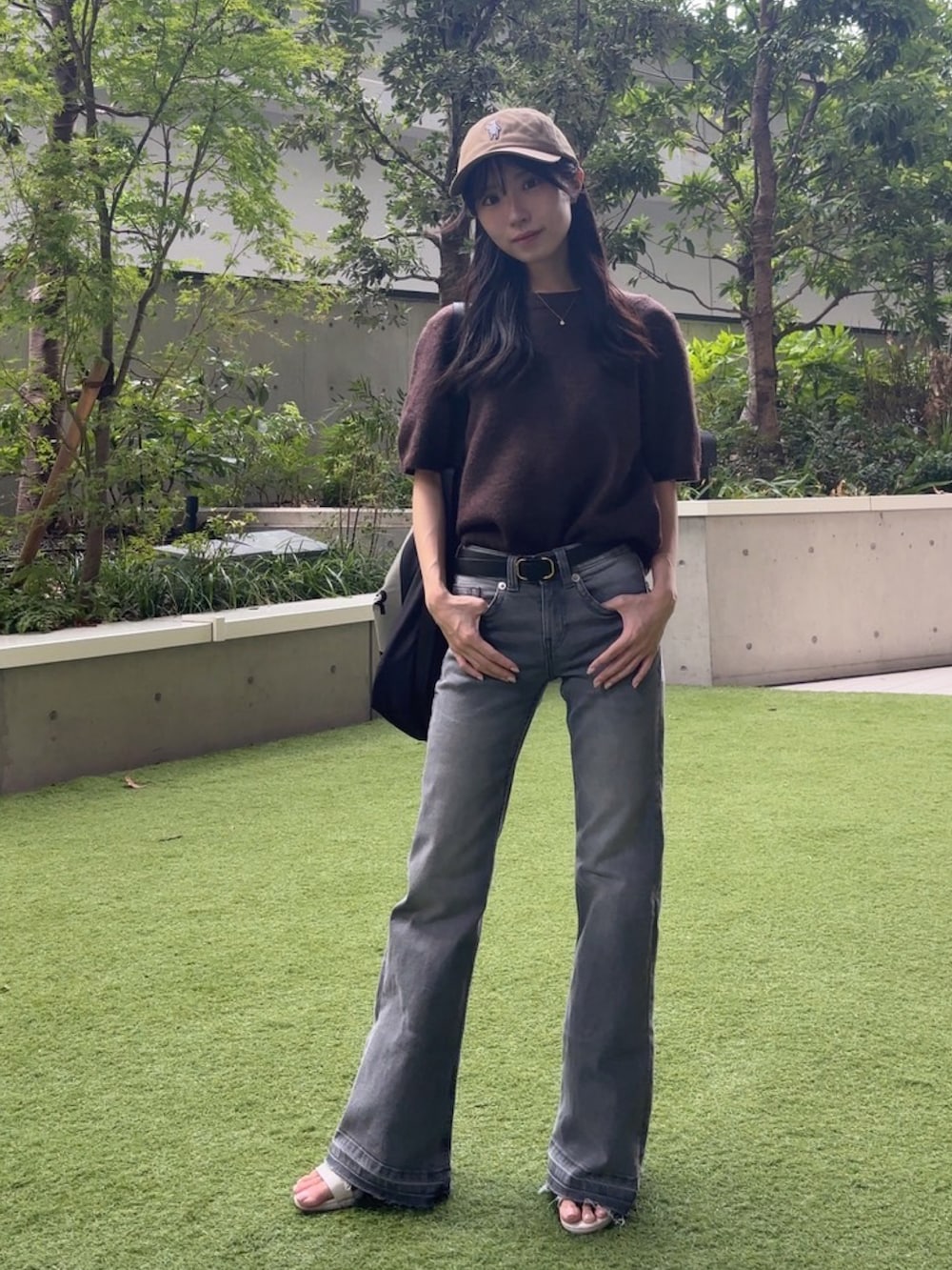 ホワイト系のサンダル、ブラウン系のニット/セーター、グレー系のデニムパンツを着用したレディースの秋コーディネートの2枚目の写真