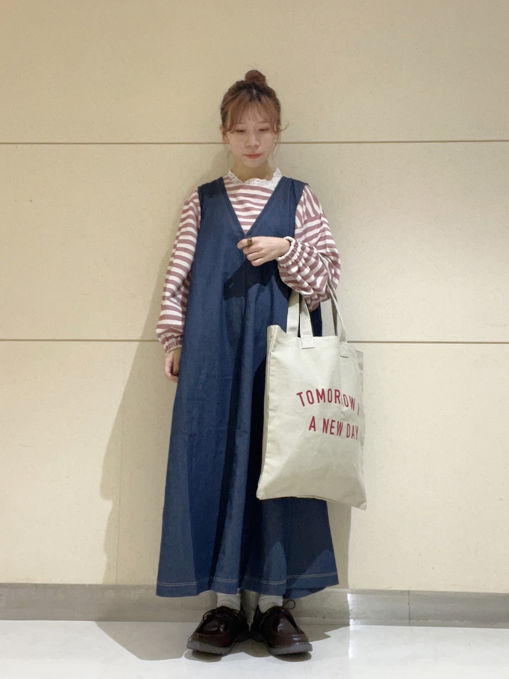 ベージュ系のハンドバッグ、ブルー系のワンピース、ピンク系のトップスを着用したレディースの夏コーディネートの2枚目の写真