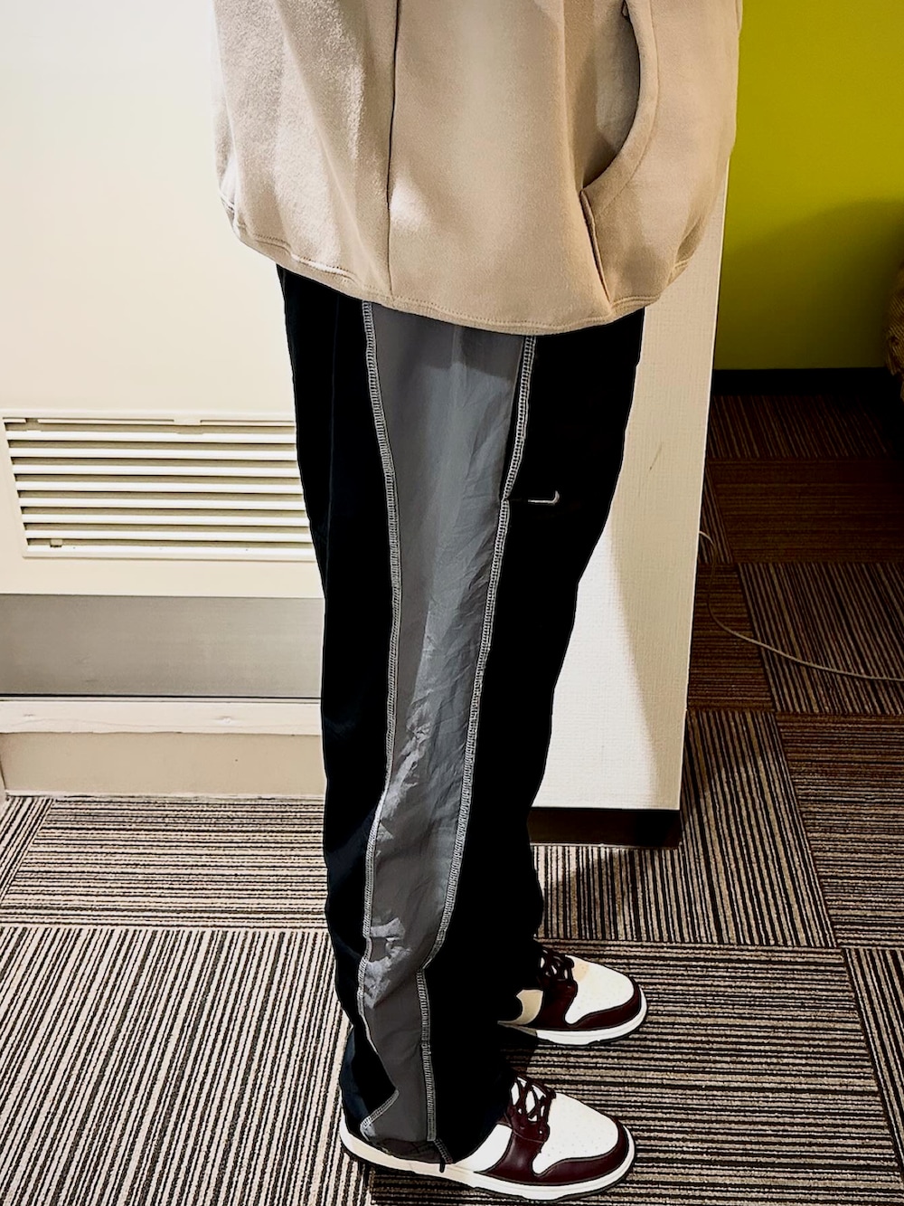 ブラック系のその他パンツ、ベージュ系のパーカー、レッド系のスニーカーを着用したメンズの春コーディネートの2枚目の写真