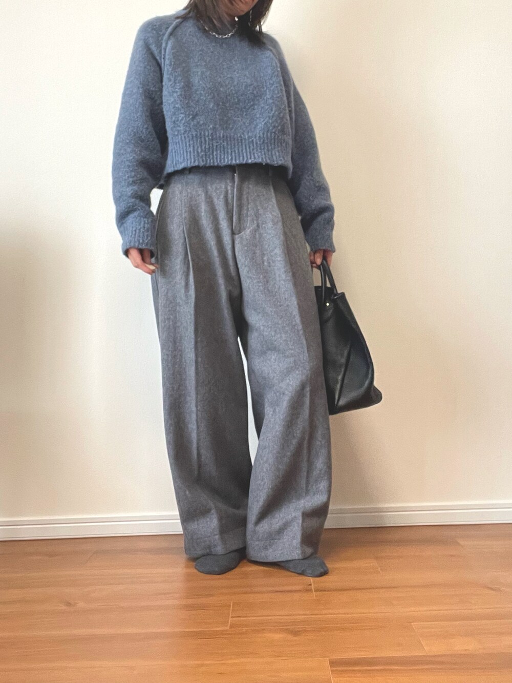 ブルー系のニット/セーター、グレー系のその他パンツ、ブラック系のトートバッグを着用したレディースの秋コーディネートの2枚目の写真