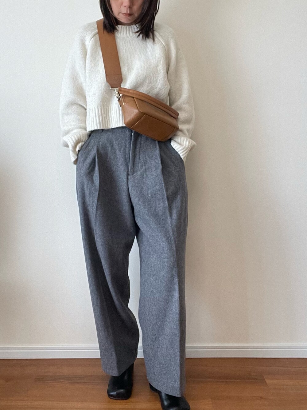 グレー系のその他パンツ、ホワイト系のニット/セーター、ブラウン系のショルダーバッグを着用したレディースの秋コーディネートの2枚目の写真