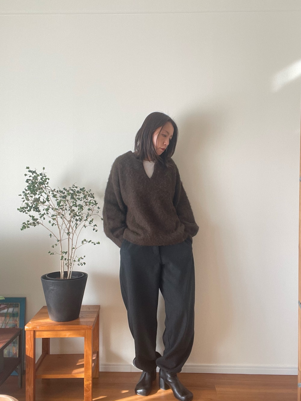 グレー系のその他パンツ、ブラウン系のニット/セーター、ブラック系のブーツを着用したレディースの秋コーディネートの2枚目の写真