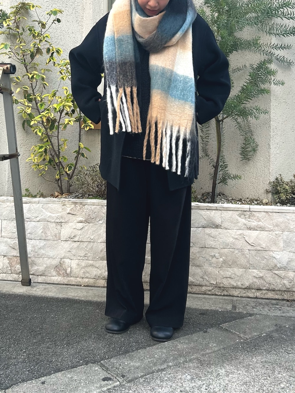 ブルー系のマフラーを着用したレディースの冬コーディネートの2枚目の写真