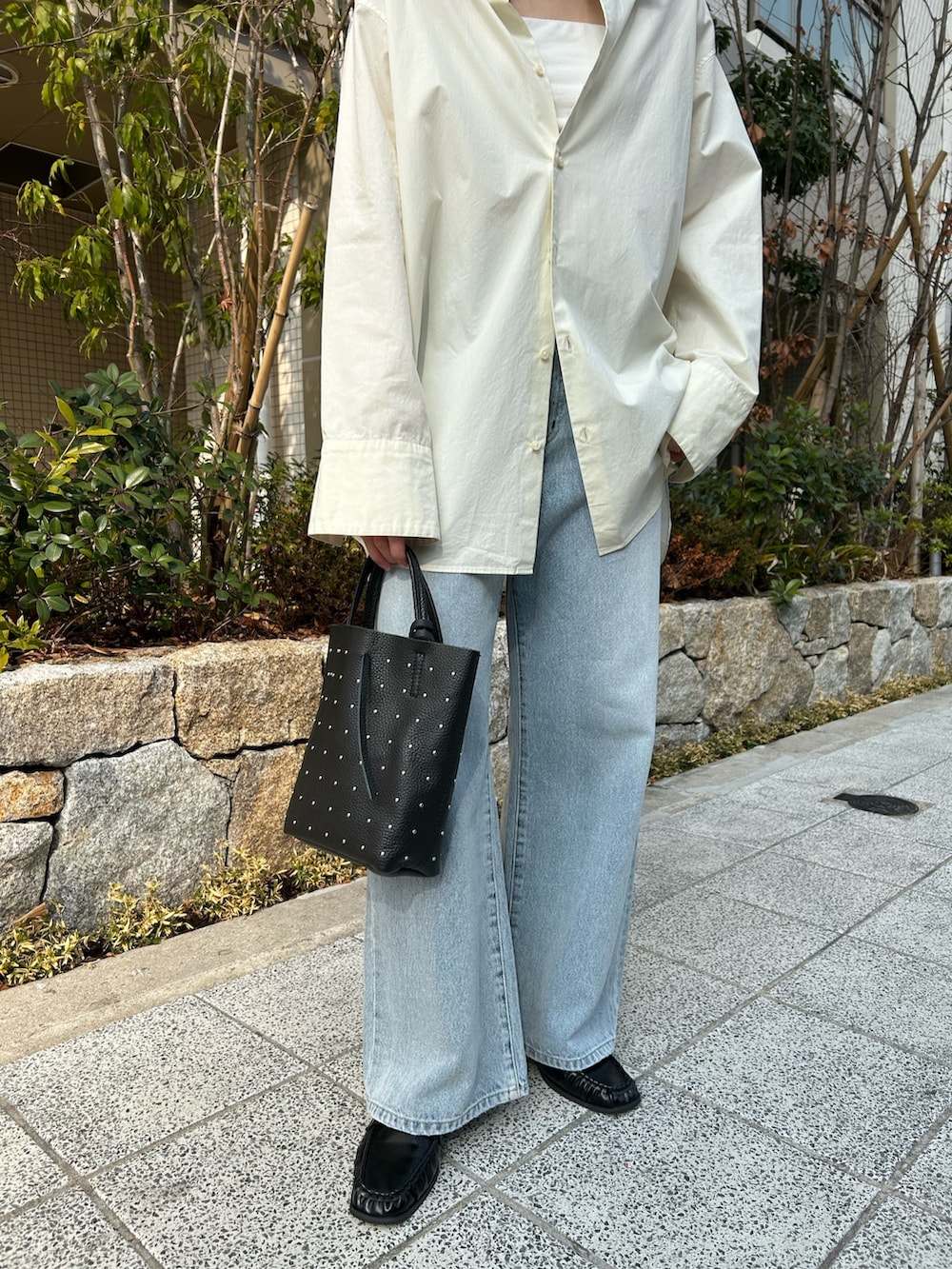 ホワイト系のシャツ/ブラウス、ブルー系のデニムパンツ、ブラック系のローファーを着用したレディースの冬コーディネートの3枚目の写真