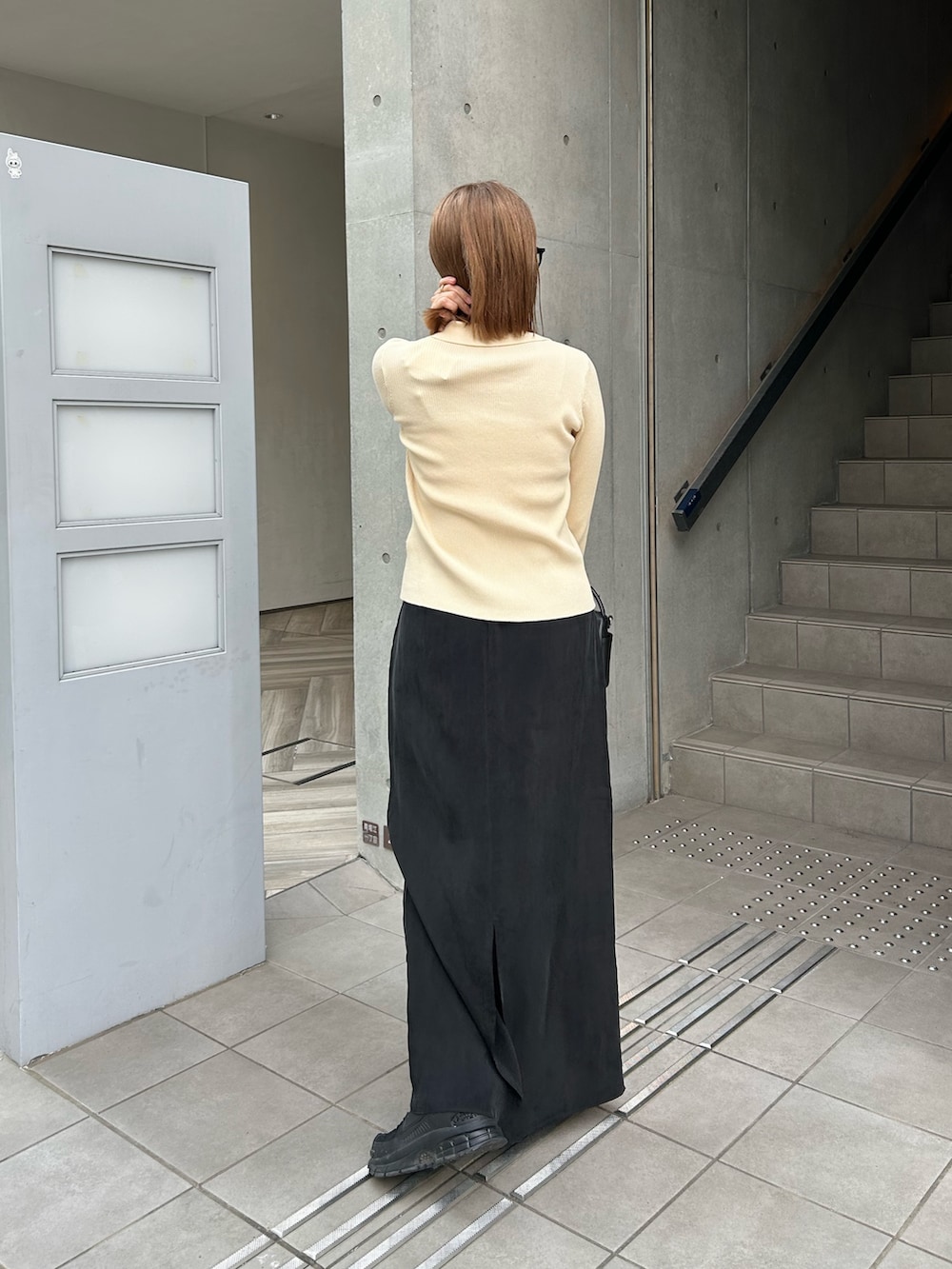 ホワイト系のカーディガン/ボレロ、ブラック系のハンドバッグ、ブラック系のスカートを着用したレディースの冬コーディネートの3枚目の写真