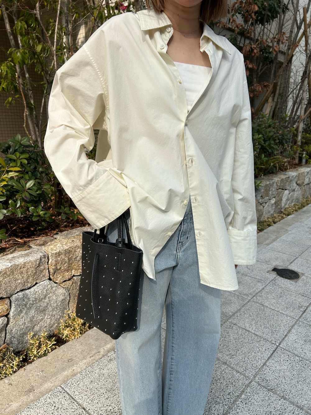 ホワイト系のシャツ/ブラウス、ブルー系のデニムパンツ、ブラック系のローファーを着用したレディースの冬コーディネートの2枚目の写真