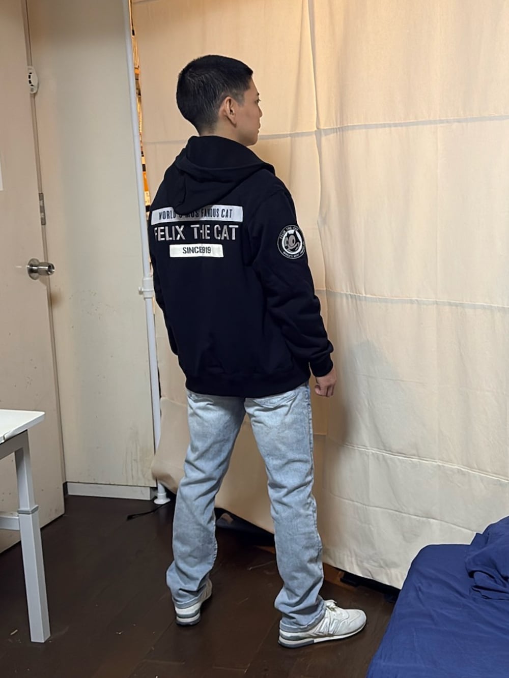 ブルー系のブルゾン、ブルー系のデニムパンツ、ホワイト系のスニーカーを着用したメンズの夏コーディネートの2枚目の写真