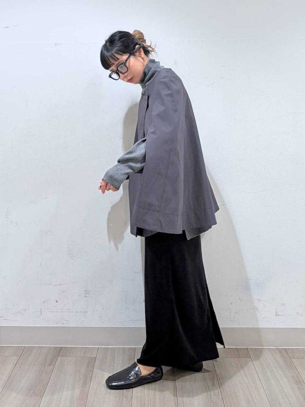 ブラック系のローファー、グレー系のポンチョ、グレー系のニット/セーターを着用したレディースの秋コーディネートの3枚目の写真