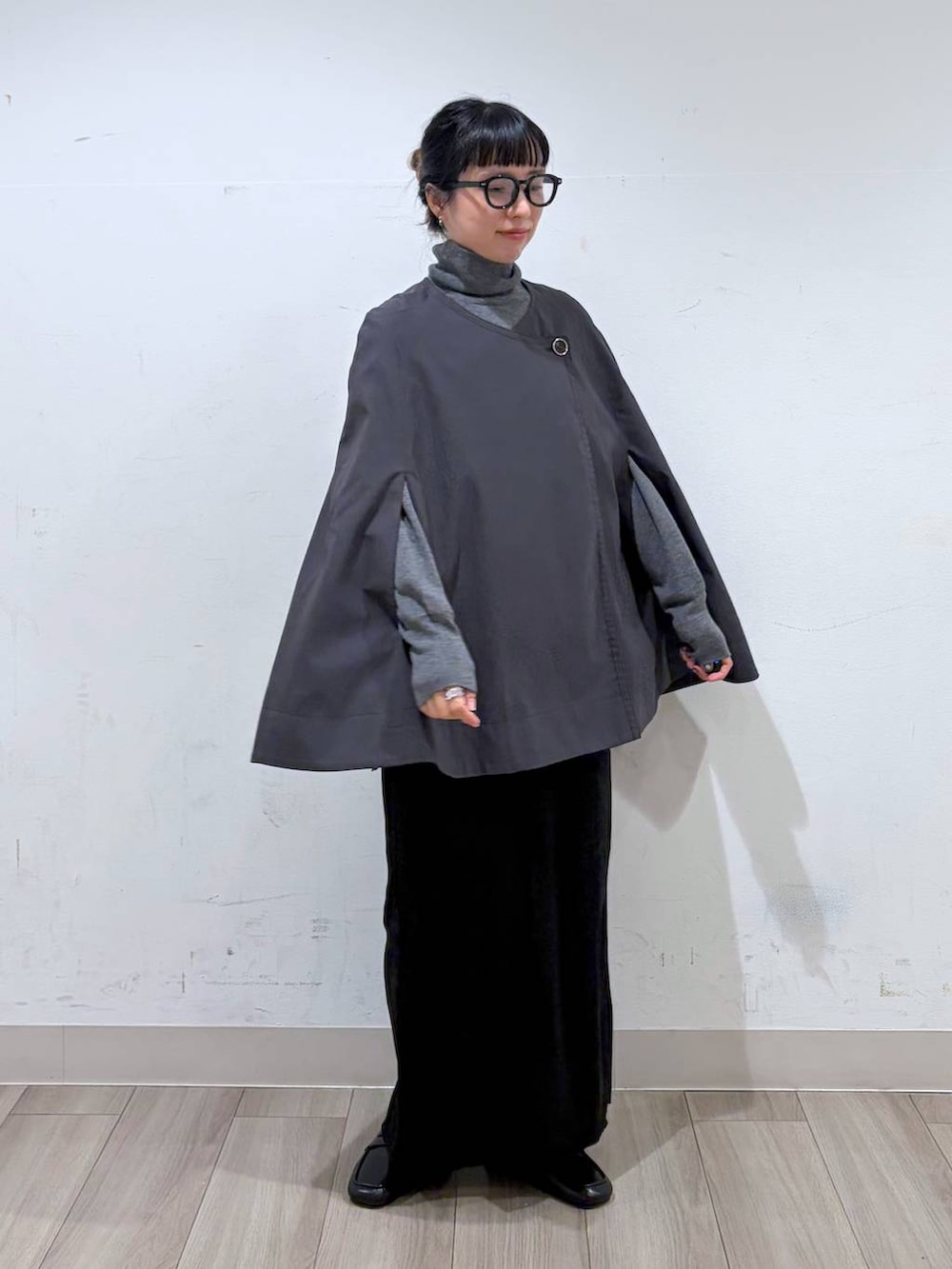 ブラック系のローファー、グレー系のポンチョ、グレー系のニット/セーターを着用したレディースの秋コーディネートの2枚目の写真