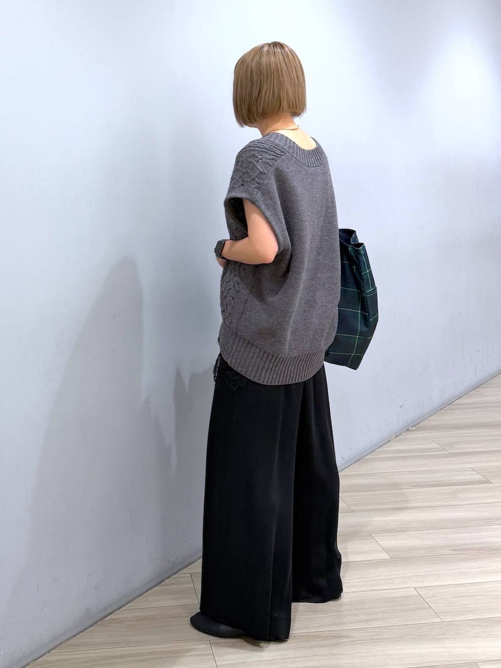 グリーン系のトートバッグ、ブラック系のキャミソール、ブラック系のパンプスを着用したレディースの秋コーディネートの2枚目の写真