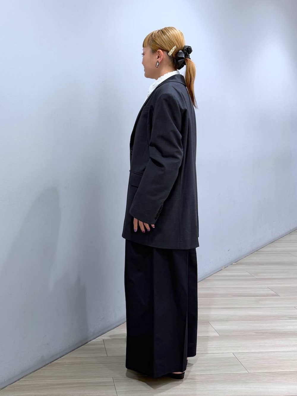 グレー系のテーラードジャケット、ブラック系のハンドバッグ、ホワイト系のシャツ/ブラウスを着用したレディースの冬コーディネートの2枚目の写真