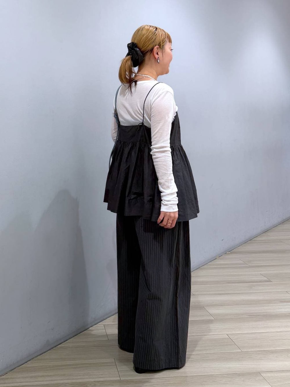 ブルー系のハンドバッグ、ホワイト系のTシャツ/カットソー、グレー系のキャミソールを着用したレディースの冬コーディネートの4枚目の写真