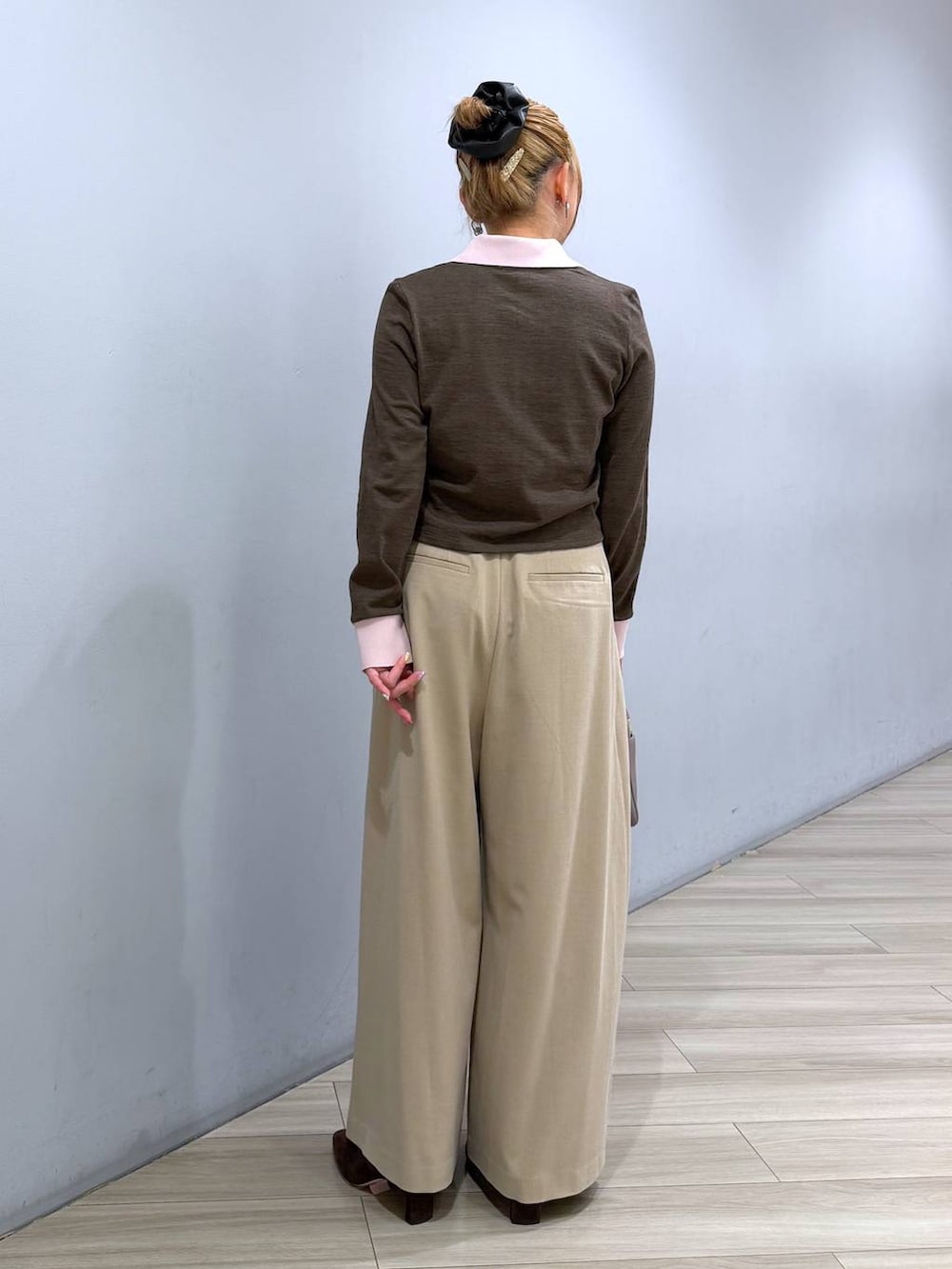 ベージュ系のボストンバッグ、ベージュ系のその他パンツ、ブラウン系のポロシャツを着用したレディースの冬コーディネートの5枚目の写真