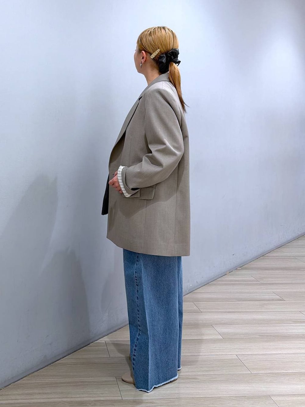 ブルー系のデニムパンツ、イエロー系のハンドバッグ、ホワイト系のTシャツ/カットソーを着用したレディースの春コーディネートの2枚目の写真