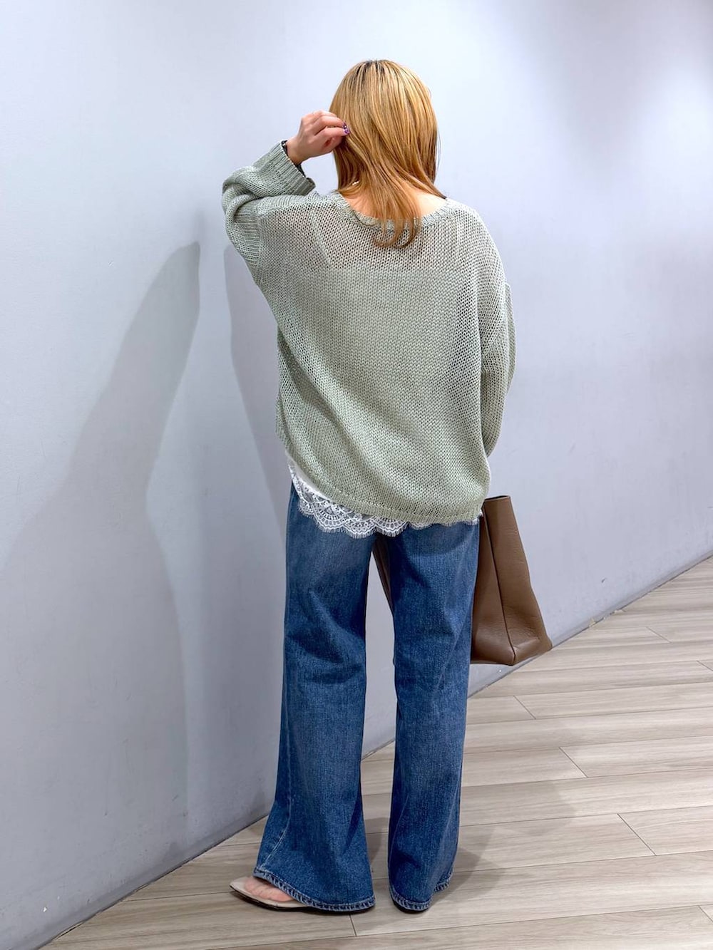 ベージュ系のパンプス、ブルー系のデニムパンツ、ホワイト系のキャミソールを着用したレディースの春コーディネートの6枚目の写真