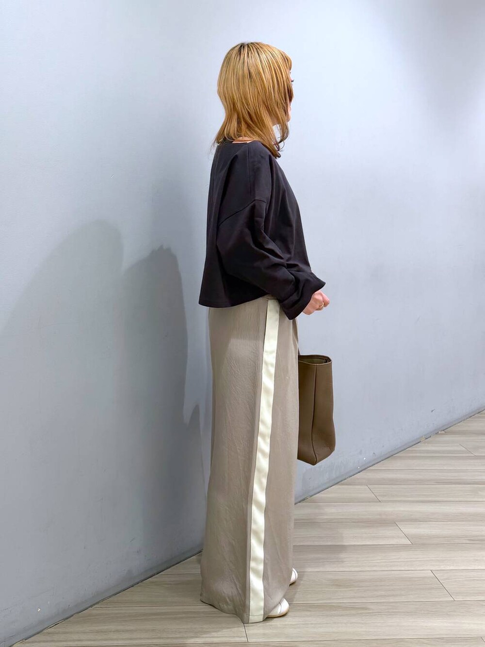 グレー系のアンサンブル、ベージュ系のその他パンツ、ホワイト系のスニーカーを着用したレディースの春コーディネートの4枚目の写真