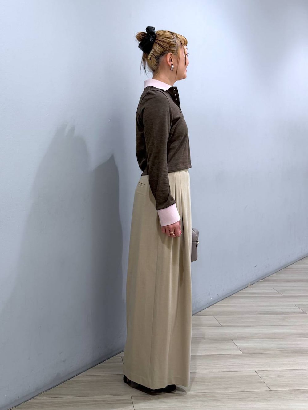 ベージュ系のボストンバッグ、ベージュ系のその他パンツ、ブラウン系のポロシャツを着用したレディースの冬コーディネートの2枚目の写真