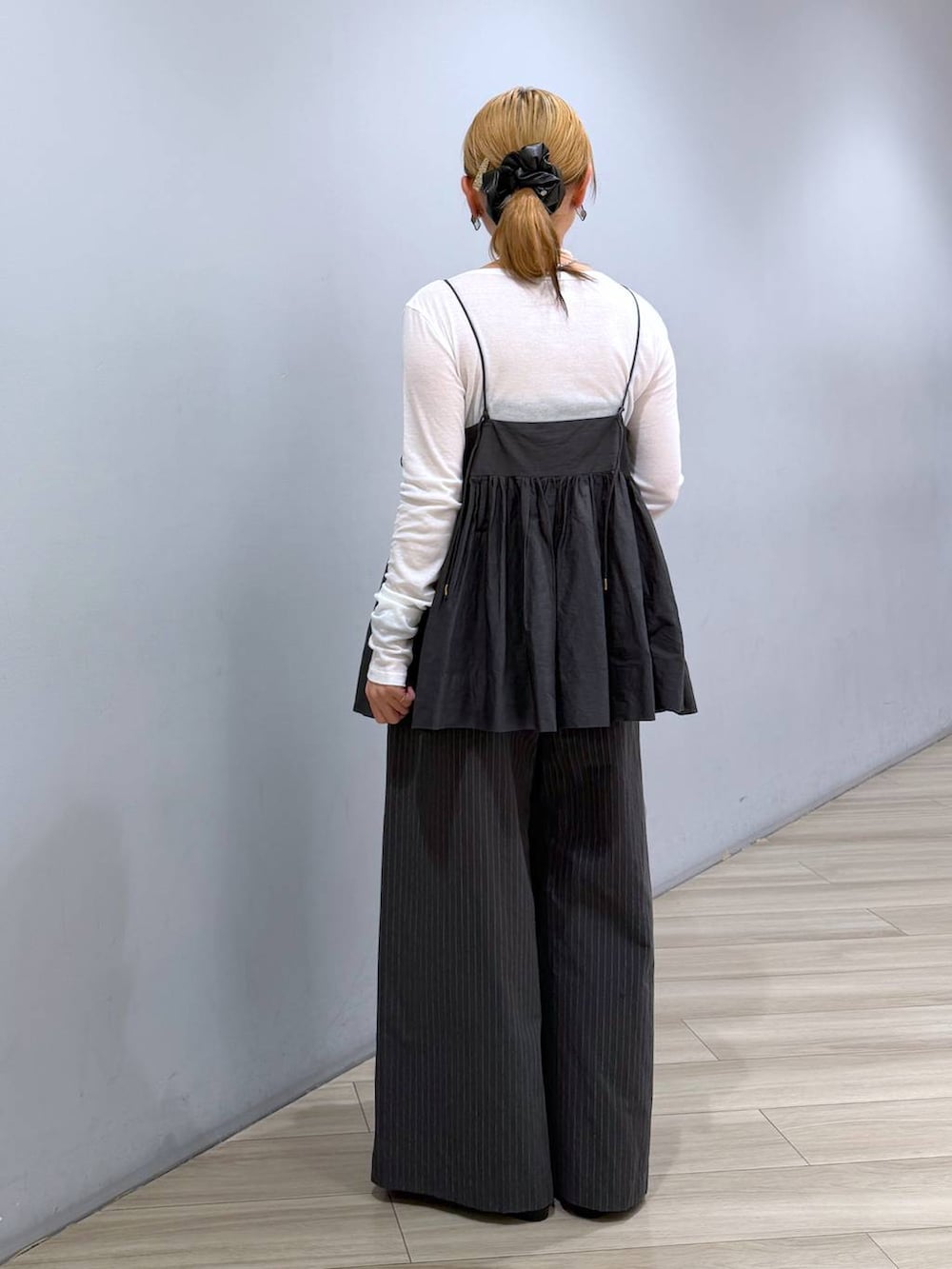 ブルー系のハンドバッグ、ホワイト系のTシャツ/カットソー、グレー系のキャミソールを着用したレディースの冬コーディネートの3枚目の写真