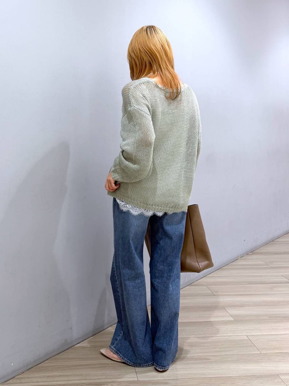 ベージュ系のパンプス、ブルー系のデニムパンツ、ホワイト系のキャミソールを着用したレディースの春コーディネートの5枚目の写真