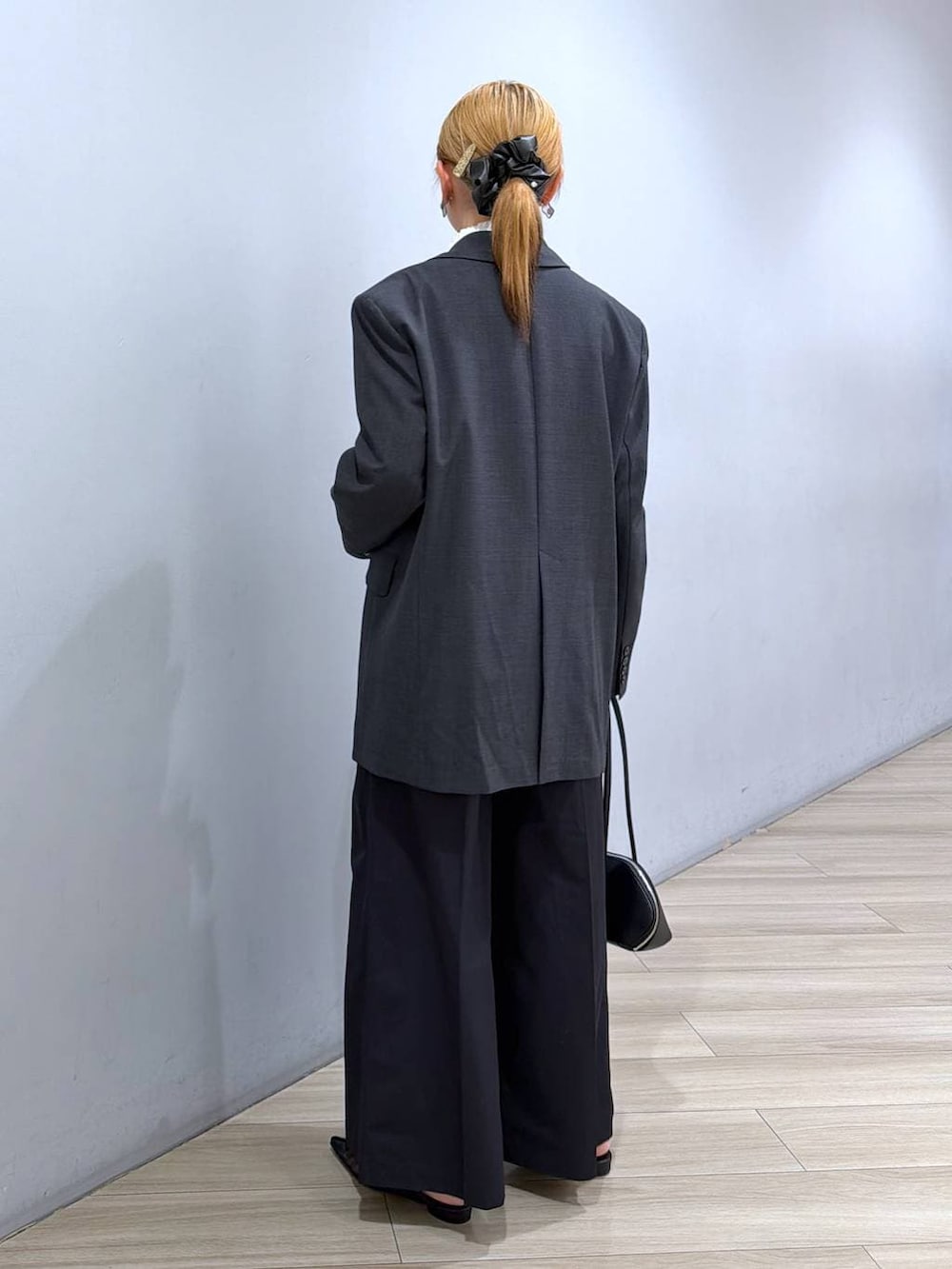 グレー系のテーラードジャケット、ブラック系のハンドバッグ、ホワイト系のシャツ/ブラウスを着用したレディースの冬コーディネートの4枚目の写真